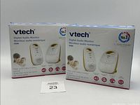 Two boxed Vtech Digital Audio Monitors shown side by side on a white surface. Boxes feature an image of the parent unit and baby unit along with marketing text and product information.