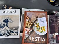 Photo of the front covers of 'Hokusai', 'Ando', 'Bestia' and a history book from the box.