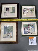 Four framed artworks laid out on flat surface with measuring tape showing approximate frame widths.