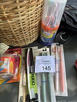 Photo showing a close view of the woven basket with toothbrushes and support bandages laid out next to it including Perio toothbrush and Smartly toothbrushes in packaging
