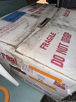 Boxed package labeled Real Fyre containing faux fireplace logs with fragile handling instructions.