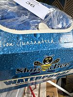 Close-up of the ShuBee waterproof shoe covers box showing branding and packaging.