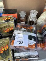 Photo showing boxes of LED pumpkin lights with some decorative glass bottles behind them inside a cardboard box.