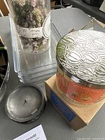 Photo showing several clear acrylic risers stacked and bundled artificial flowers, next to a small silver bowl and Bath & Body Works candle in box