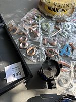 Silver and bronze peel and stick numbers individually packaged in plastic, arranged on flat surface with quarantine tape visible nearby.