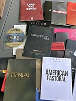 Photo showing assorted DVD screener covers including Long Way North, Snowden, Anthropoid, The VVitch, Manchester by the Sea, Black Swan, American Pastoral, Denial, and Argo Declassified disc.