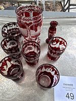 Photo showing the red etched glass set including cordial glasses, small vases, and bowl on silver tray