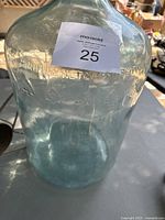 Close-up photo of the vintage 5 gallon Arrowhead glass water bottle showing embossed text and overall shape.