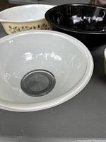 White Pyrex mixing bowl with silver bottom, black and cream Pyrex bowls with leaf patterns