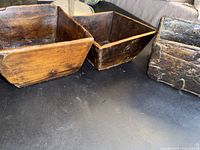 Three wooden bowls arranged side by side on dark surface