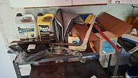 Overall view of shelving holding Prestone antifreeze containers, boxed scissors jack, visors, crowbar, and assorted garage tools