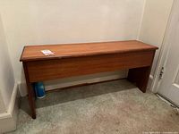 Front view of wood storage bench showing structure and scuffs under.