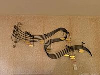 Full view of metal music note wall sculpture on wallpapered wall
