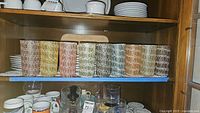 Shelf with all 9 tumblers in assorted colors arranged side by side showing the spaghetti string pattern design