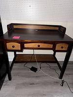 Front view of petite wooden desk with three drawers and wooden accents
