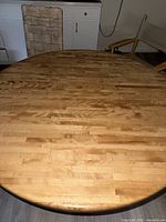 Top view of butcher block round dining table showing wood strips and natural finish.