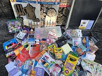 Overview of arts and crafts supplies including paints, crayons, colored pencils, brushes, dyes, decorative stamping kits, glitter tapes, scissors, glue and stickers.