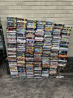 Front view of multiple stacks of DVD cases arranged against a brick wall