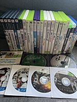 Photo showing a collection of video game cases and loose discs arranged in rows with titles visible