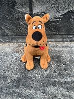 Clear photo of a small brown Scooby-Doo plush toy showing its front view, facial features, and sitting posture.