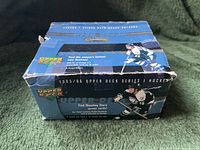 Blue Upper Deck branded box for 2005/06 hockey cards with promotional text and images of hockey players. The box is worn and slightly damaged.