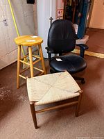Three piece set showing the black office chair, wooden bar stool, and MCM footstool with woven cord seat together on floor