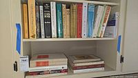 Shelf of various cookbooks including classic and international titles, stacked and lined up.