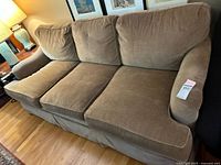 Front angle view of brown upholstered Ethan Allen sleeper sofa with three seat and back cushions. Sofa appears well maintained with minor signs of use.