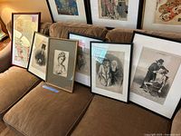 Overview of six framed prints leaning on sofa: four Daumier caricatures, classical bust, color map, Show Boat sheet music.