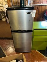 Front view of Franklin Chef refrigerator freezer showing stainless steel doors, black trim between compartments, and brand label.
