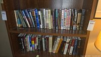 Two full shelves of hardcover books showing various titles and authors.