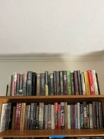 Books arranged on shelves, displaying a variety of hardcover fiction titles.