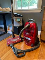 Kenmore Progressive vacuum with hose, wand, and floor nozzle shown on hardwood floor near window under natural light.
