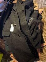 Stack of six men's coats and jackets in various styles and colors