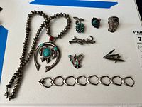 Main overview showing all eight pieces: necklace, brooches, rings, pin, pendant, bracelet