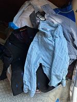 Overview photo showing a pile of toddler boys' clothing including shirts, blazer, and swimwear