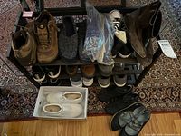 Full view of the shoe rack showing multiple pairs of women's footwear including boots, sneakers, flats, slippers in various colors and styles.
