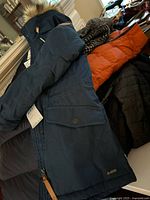 Navy Fjallraven parka laid flat showing faux fur hood and G-1000 label
