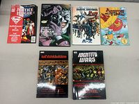 Photo showing six comic books laid out in two rows: Justice League, Batman, Marvel Universe A-Z, Adventure Time, Marvel Ultimatum, Identity Wars.