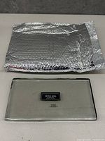 Top-down photo of the rectangular Crown Jewel glass serving platter alongside silver protective bubble wrap.