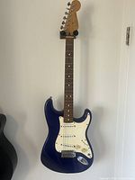 Full front view of guitar hanging on wall