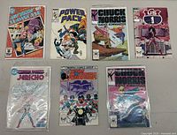 Photo showing seven vintage comic books featuring Power Pack, Chuck Norris Karate Kommandos, US 1, Jericho, Team America, and The New Talent Showcase titles.