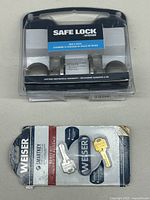 Weiser Safe Lock Bed & Bath door knob set in sealed packaging, showing the round knobs and latch, label displaying product name and features.