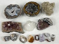 Overview of collection items including agate slices, quartz crystals, and small mineral specimens on white cloth background.