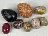 Overview of 8 polished stone eggs in various colors and patterns showing size and details.