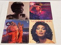 Photo showing four vintage vinyl records with female vocalists including Nancy Wilson, The Jones Girls, and Patti Austin. Covers show heavy wear. Discs appear clean and playable.