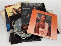 Photo of vintage vinyl record covers showing various female soul and pop vocalists including Whitney Houston, The Supremes, and Aretha Franklin.