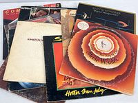 Stacked album covers including Stevie Wonder and others