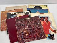 Overview photo of 12 vintage vinyl albums arranged overlapping, showing front covers with some wear.