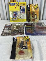 All four figures in packaging, visible damage to some packages, showing variety and scale of figures.